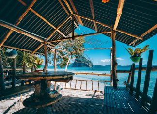 Tropical getaway remote panorama of impressive Pinagbuyutan island from the native wood and bamboo terrace, beauty of Philippines island