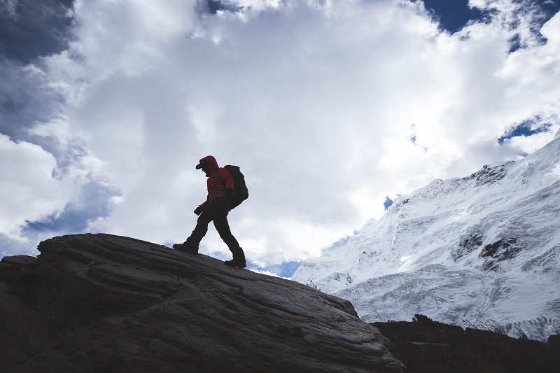 Woman hiker walking on winter mountain top  cliff edge