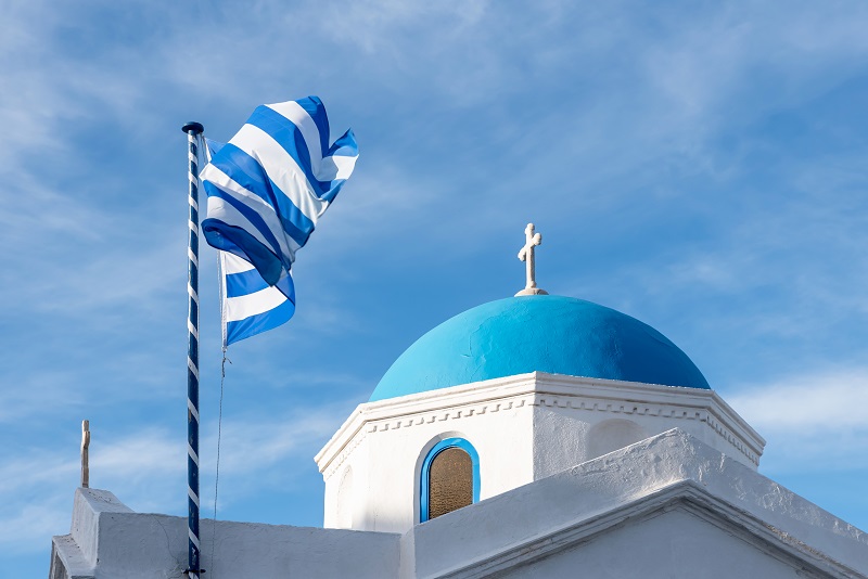 Greek flag and orthodox church in Mykonos, Greece