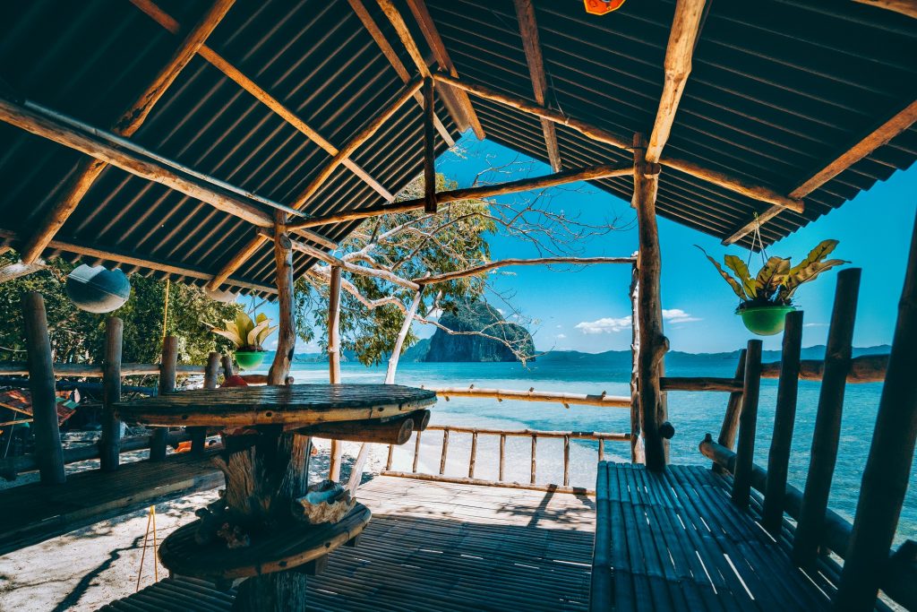 Tropical getaway remote panorama of impressive Pinagbuyutan island from the native wood and bamboo terrace, beauty of Philippines island