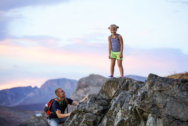 Young girl and father enjoying active vacations in mountains