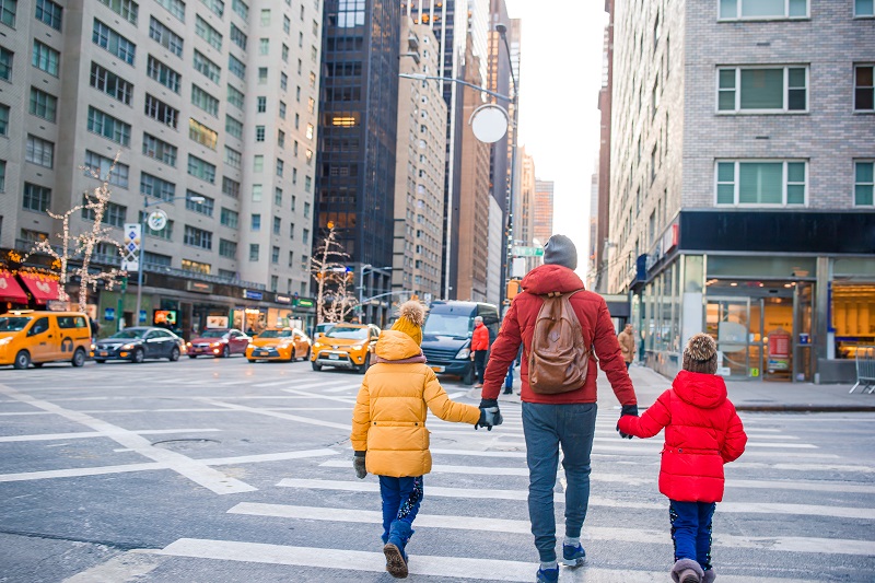 Family of father and little kids on Times Square during their vacation in New York City