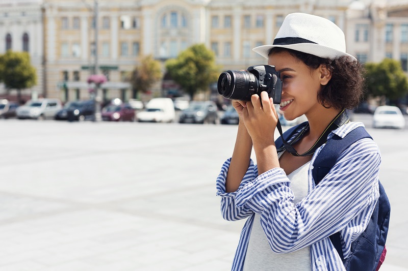 African-american woman photographing with camera on vacation