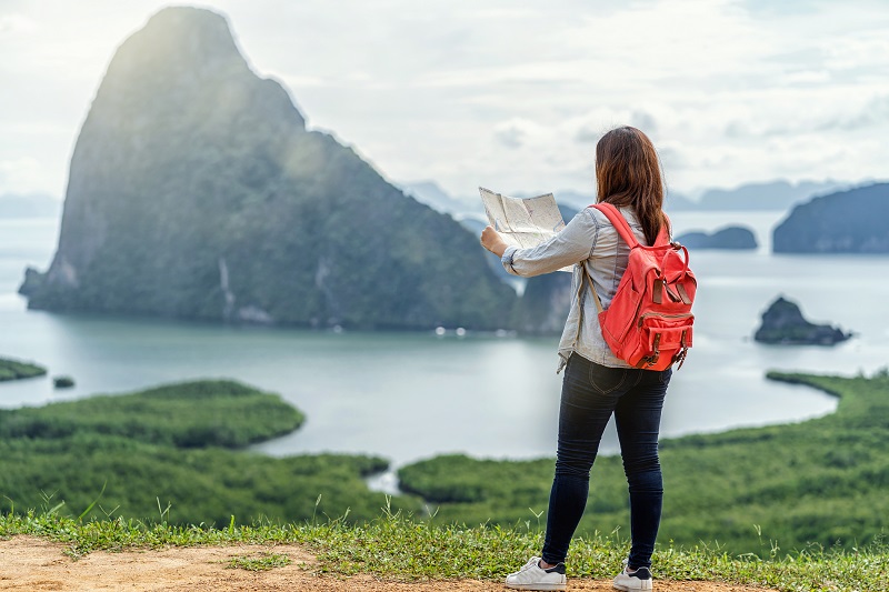 Back side of Asian woman traveler looking the map for travel wit