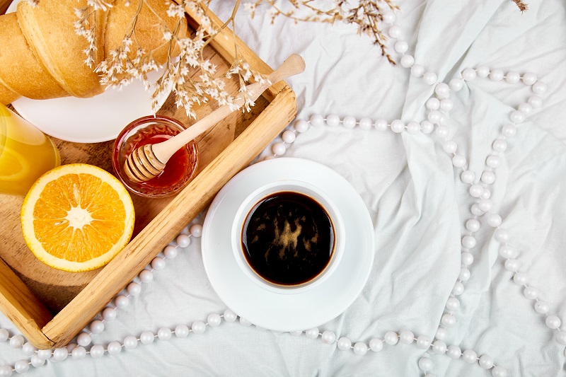 Good morning. Continental breakfast on white bed sheets.