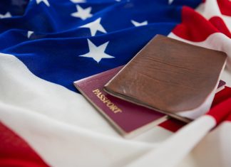 Close-up of passport and visa on an American flag