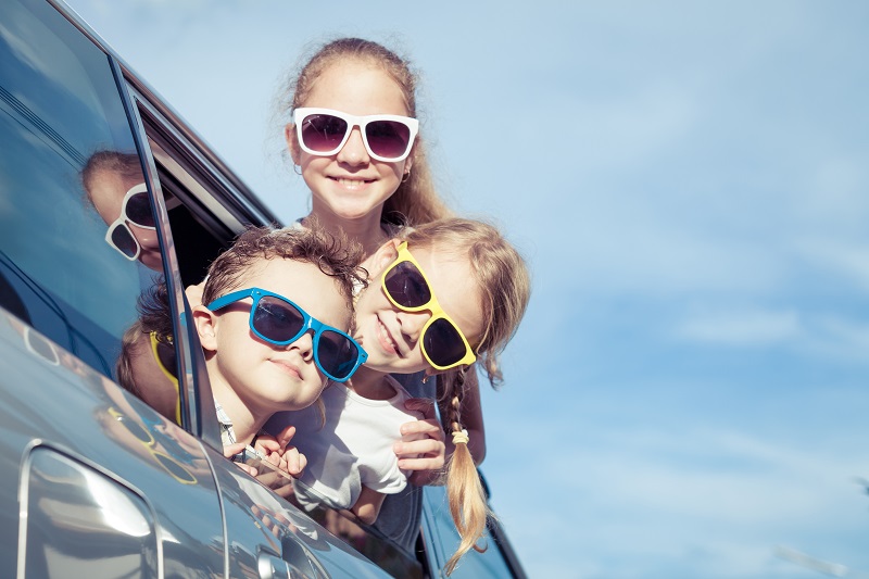 Happy children getting ready for road trip on a sunny day