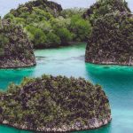 Painemo, Group of small island in shallow blue lagoon water, Raja Ampat, West Papua, Indonesia