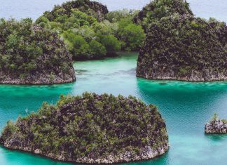 Painemo, Group of small island in shallow blue lagoon water, Raja Ampat, West Papua, Indonesia