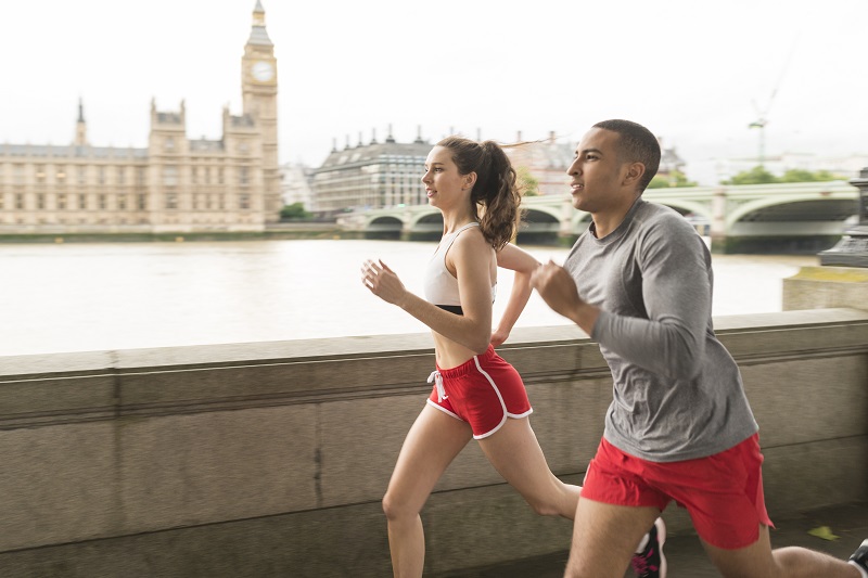 Male and female runners running along Southbank, London, UK
