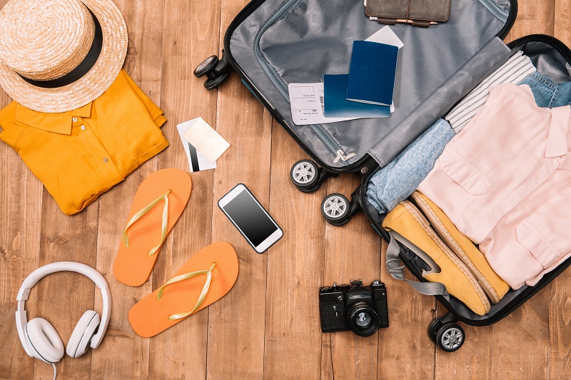 Ready for travel concept. Top view of essentials for tourist with clothes, accessories and gadgets,
