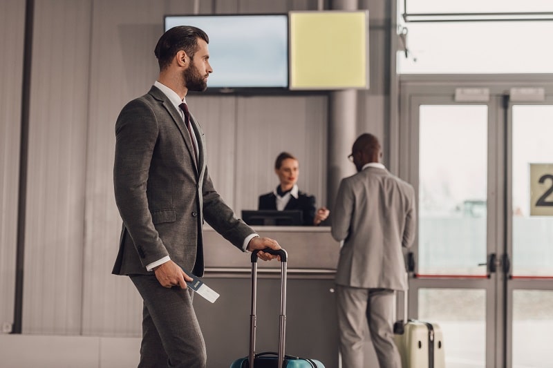 businessman with luggage and flight ticket at airport