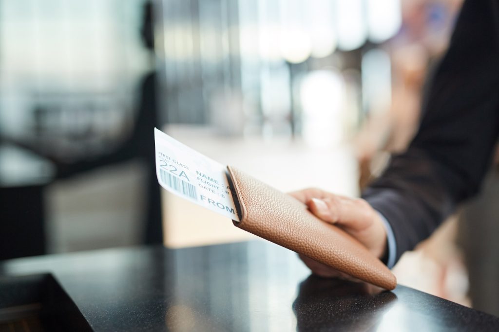 Hand Holding Passport And Flight Ticket