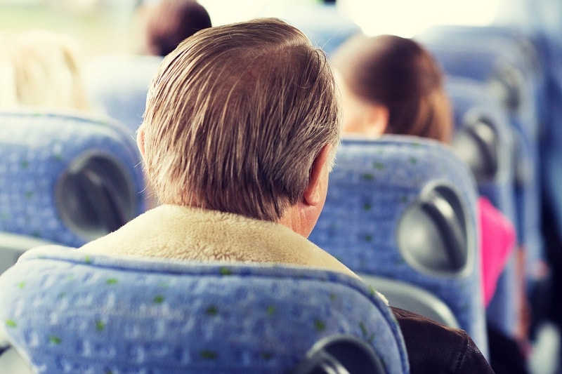 close up of senior man sitting in travel bus