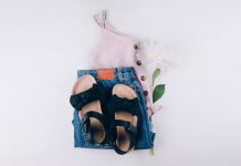 Summer fashion outfit - top, denim shorts, black sandals. Female travel vacation clothes. Flat lay