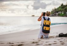 Travel tourist female photograph sunset at tropical beach. Recreation hobby summer vacation lifestyle concept