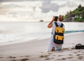 Travel tourist female photograph sunset at tropical beach. Recreation hobby summer vacation lifestyle concept