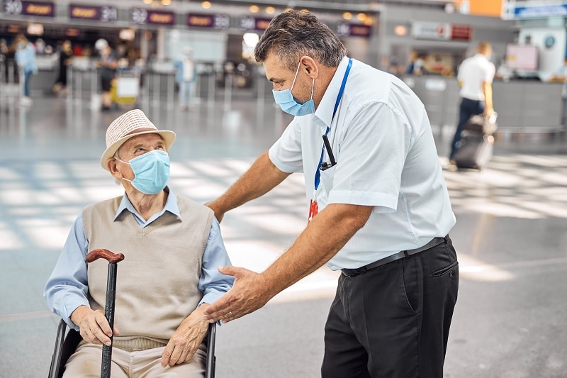 Airline worker communicating with a disabled man