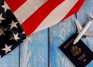 Travel tourism, emigration the USA American flag with U.S. passport and passenger model plane airplane