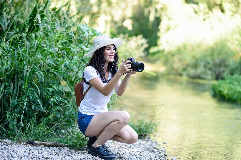 Hiker woman taking photographs with a mirrorless camera