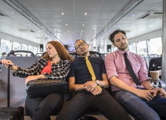 Businesswoman and men asleep on passenger ferry