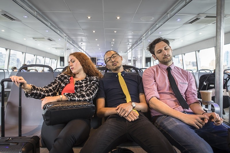 Businesswoman and men asleep on passenger ferry