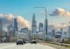 Chicago Illinois, USA. Cars on the road driving to Chicago city, high rise buildings and cloudy sky background