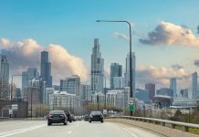 Chicago Illinois, USA. Cars on the road driving to Chicago city, high rise buildings and cloudy sky background