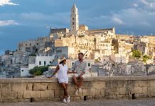 A couple enjoys the stunning sunset view over Matera ancient stone architecture in Puglia, Italy